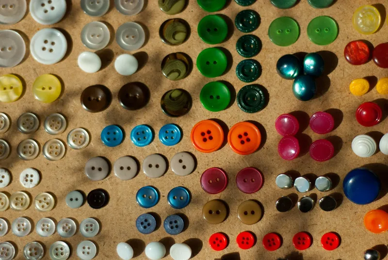Botones de colores agrupados por color y forma sobre una mesa