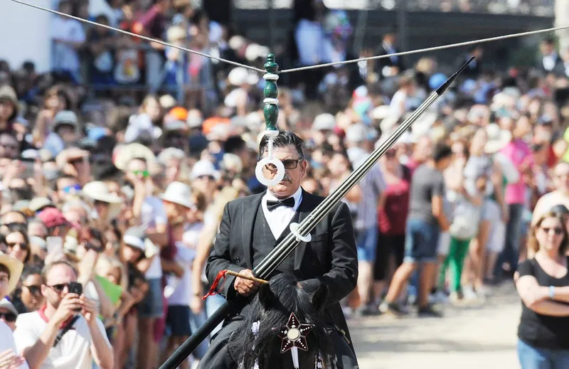 Caballero con la lanza de s’Ensortilla rodeado de público en las fiestas de Sant Joan de Ciutadella